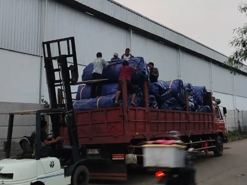 Pemuatan terpal biru YO TERPAL NUSANTARA RAYA ke truk engkel dengan forklift