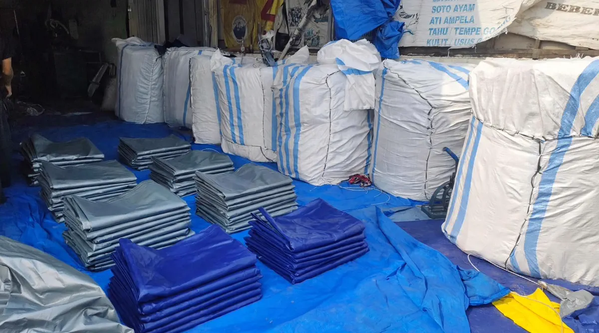 Gudang YO TERPAL NUSANTARA RAYA penuh stok terpal terkemas karung dan tumpukan lembar siap kirim
